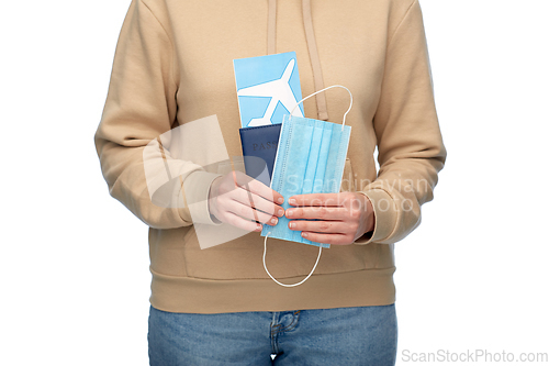 Image of woman with mask, passport and air ticket