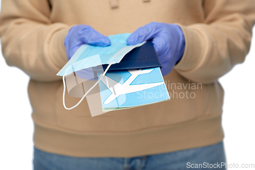 Image of woman with mask, passport and air ticket