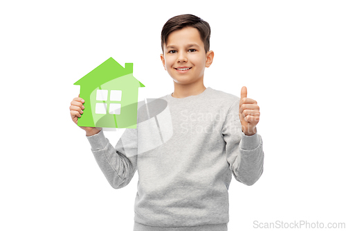 Image of smiling boy with green house and showing thumbs up