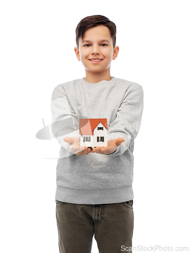 Image of smiling boy holding house model