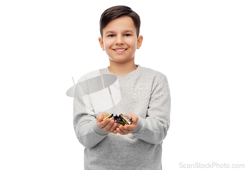 Image of smiling boy holding pile of alkaline batteries