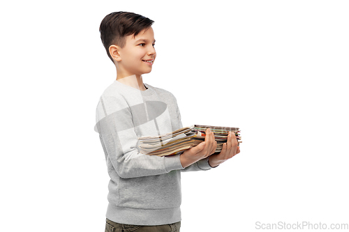 Image of smiling boy with magazines sorting paper waste