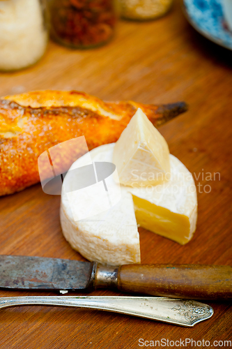 Image of French cheese and fresh  baguette on a wood cutter