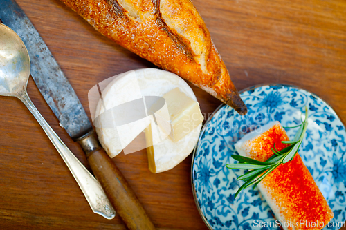 Image of French cheese and fresh  baguette on a wood cutter