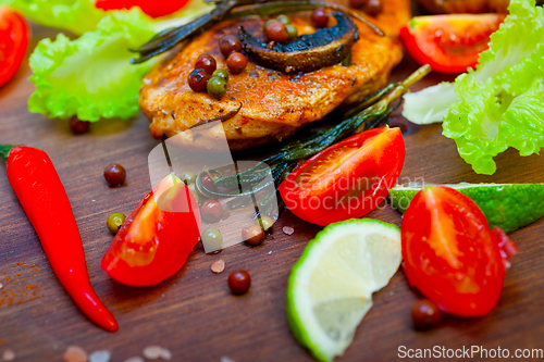 Image of wood fired hoven cooked chicken breast on wood board