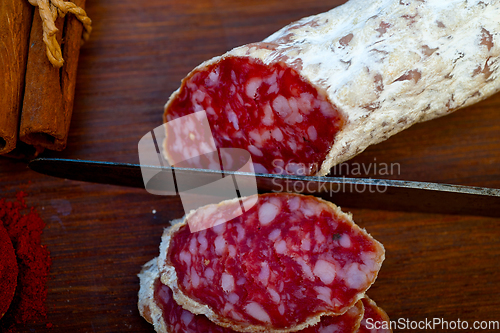 Image of traditional Italian salame cured sausage sliced on a wood board