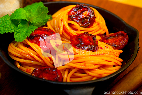 Image of italian spaghetti pasta and tomato with mint leaves