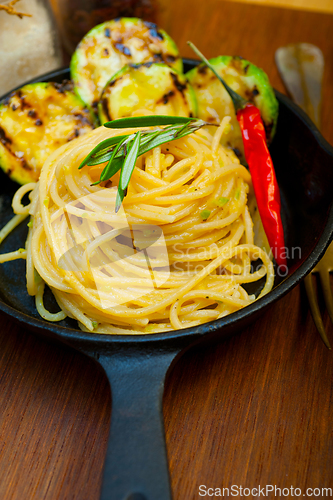 Image of italian spaghetti pasta with zucchini sauce on iron skillet