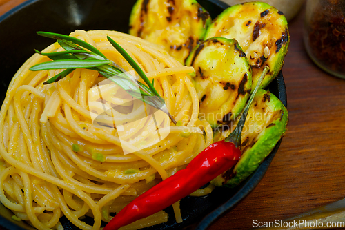 Image of italian spaghetti pasta with zucchini sauce on iron skillet