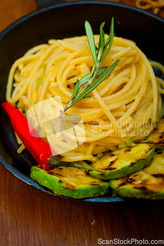 Image of italian spaghetti pasta with zucchini sauce on iron skillet