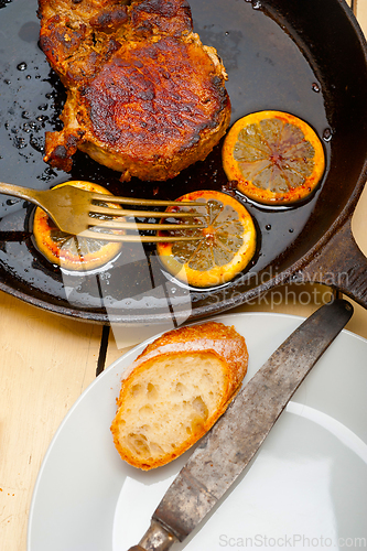 Image of pork chop seared on iron skillet