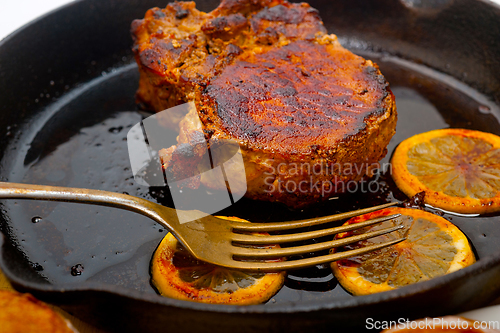 Image of pork chop seared on iron skillet