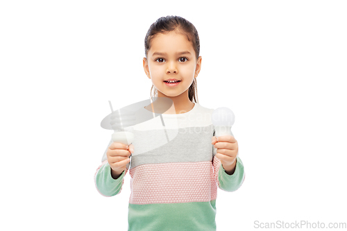 Image of smiling girl comparing different light bulbs