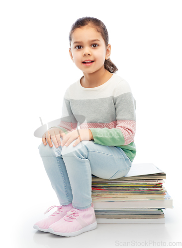 Image of smiling girl with magazines sorting paper waste