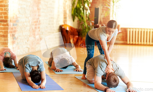 Image of group of people doing yoga exercises at studio