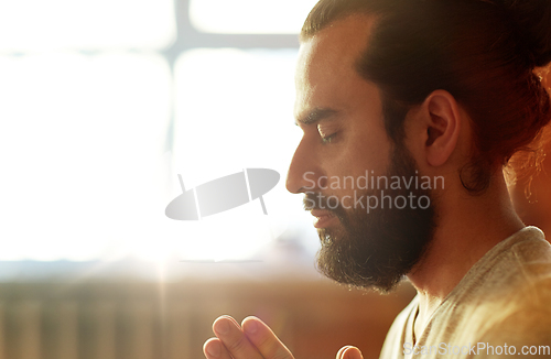 Image of close up of man meditating at yoga studio