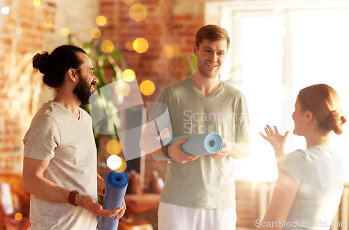 Image of group of people with mats at yoga studio or gym
