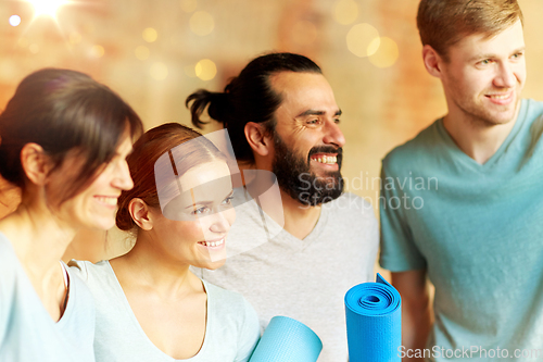 Image of group of people with mats at yoga studio or gym