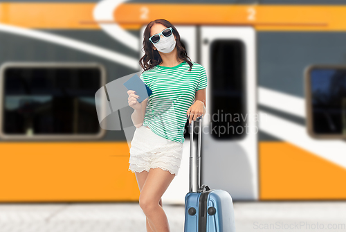 Image of teenage girl in mask with travel bag and passport