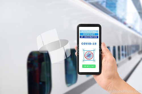 Image of hand holding phone with certificate of vaccination