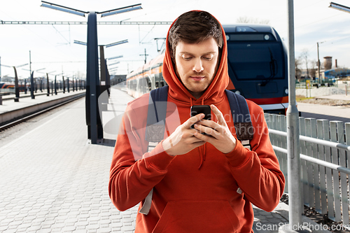 Image of man with smartphone traveling by train