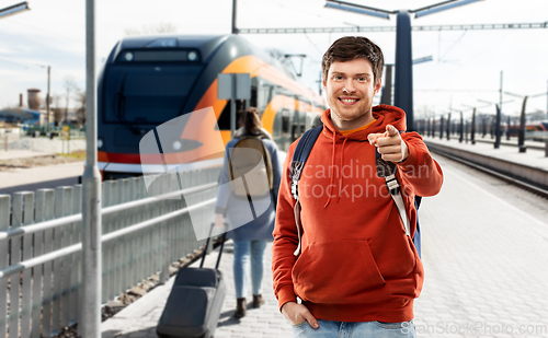 Image of smiling man with backpack traveling by train