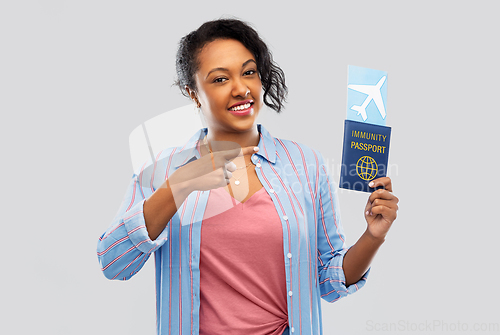 Image of happy woman with air ticket and immunity passport