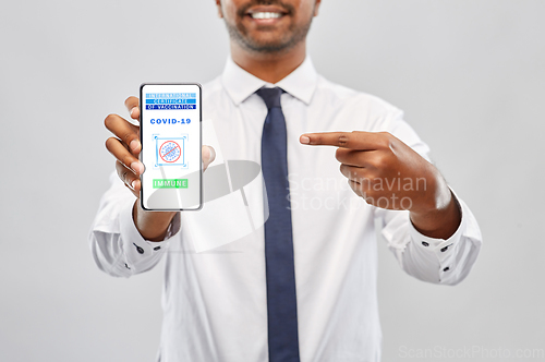Image of man with certificate of vaccination on smartphone