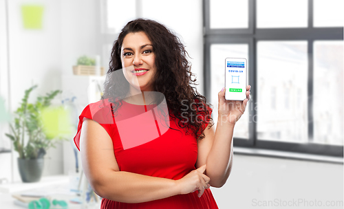 Image of woman with certificate of vaccination on phone