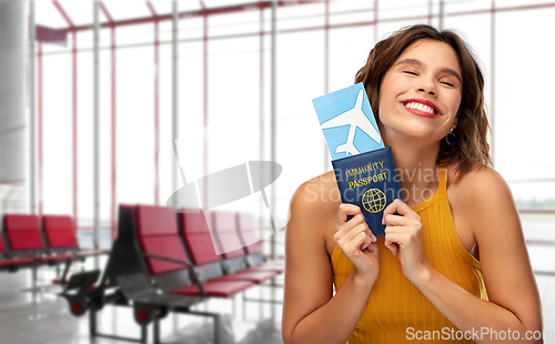 Image of happy woman with air ticket and immunity passport