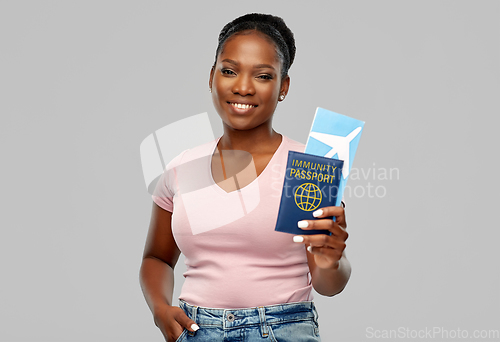 Image of happy woman with air ticket and immunity passport