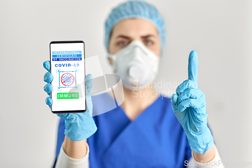 Image of doctor with immunity passport on smartphone screen