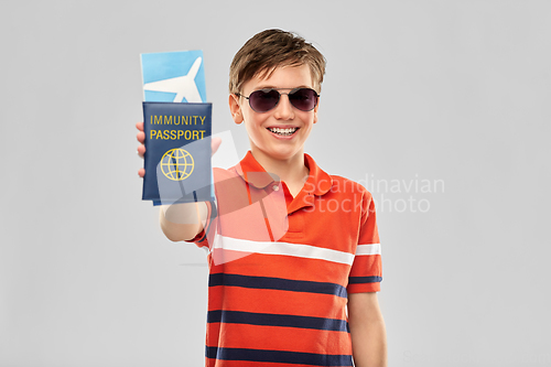 Image of happy boy with air ticket and immunity passport