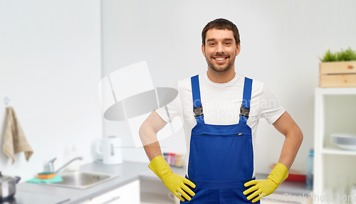 Image of happy male worker or cleaner in gloves at kitchen