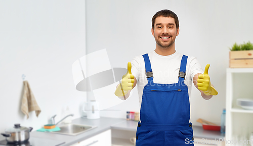 Image of happy male worker or cleaner in gloves at kitchen