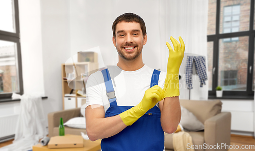 Image of male worker or cleaner wearing gloves at home