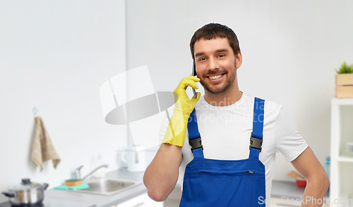 Image of male worker or cleaner calling on phone at kitchen