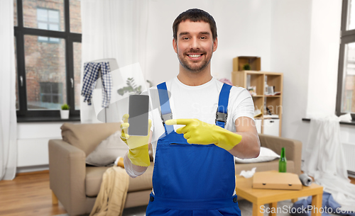 Image of male worker or cleaner showing smartphone at home