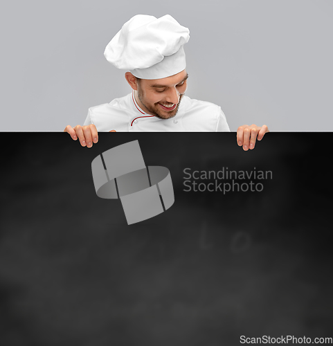 Image of happy smiling male chef with big black chalkboard