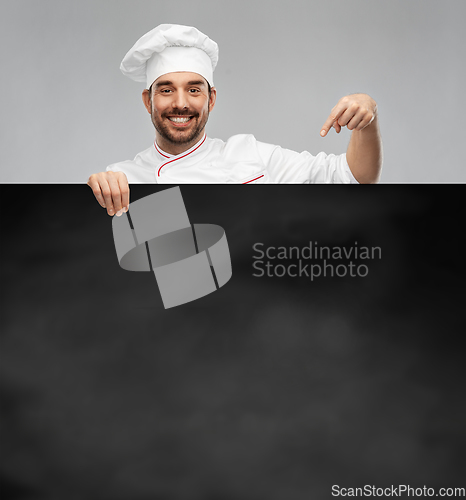 Image of happy smiling male chef with big black chalkboard