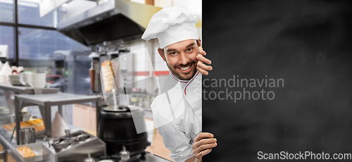 Image of happy smiling male chef with big black chalkboard