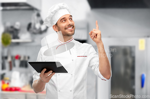 Image of male chef with tablet computer pointing finger up