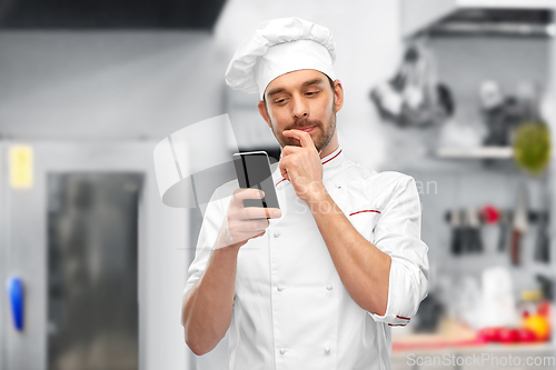 Image of male chef with smartphone at restaurant kitchen