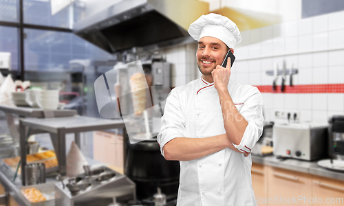 Image of happy smiling male chef calling on smartphone