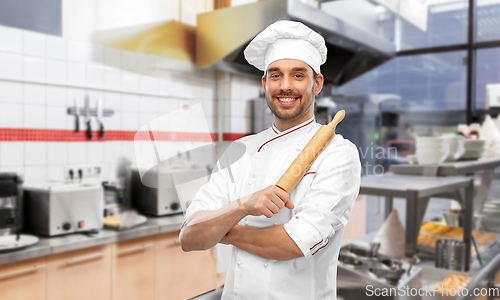 Image of happy male chef with rolling pin at kitchen