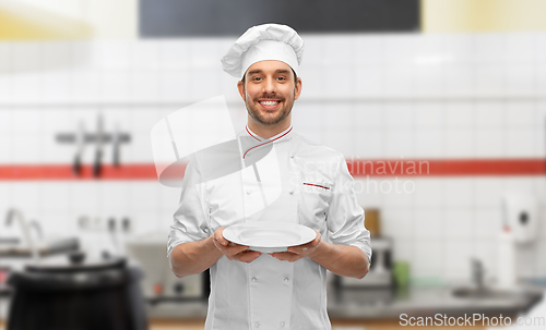 Image of happy smiling male chef holding empty plate