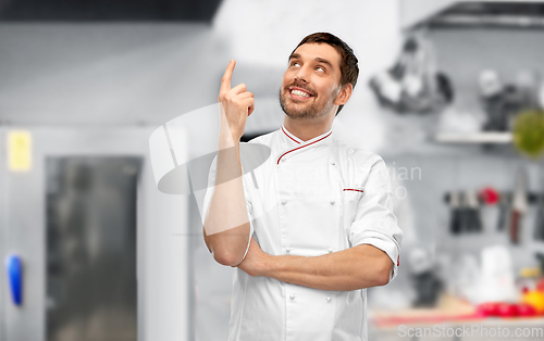 Image of happy smiling male chef pointing finger up