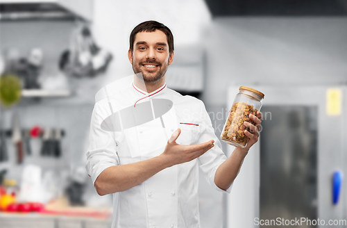 Image of happy smiling male chef with pasta in glass jar