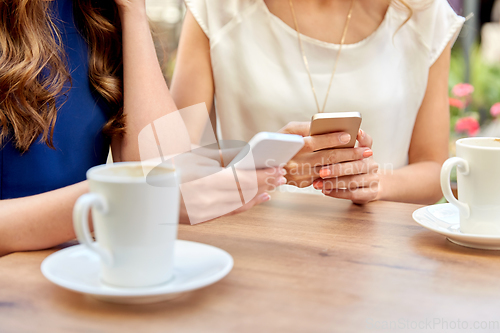 Image of close up of women with smartphone at street cafe