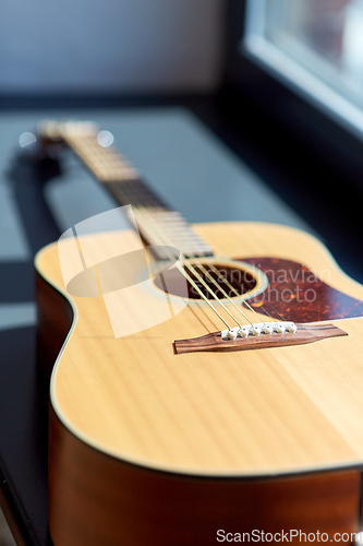 Image of close up of acoustic guitar on window sill